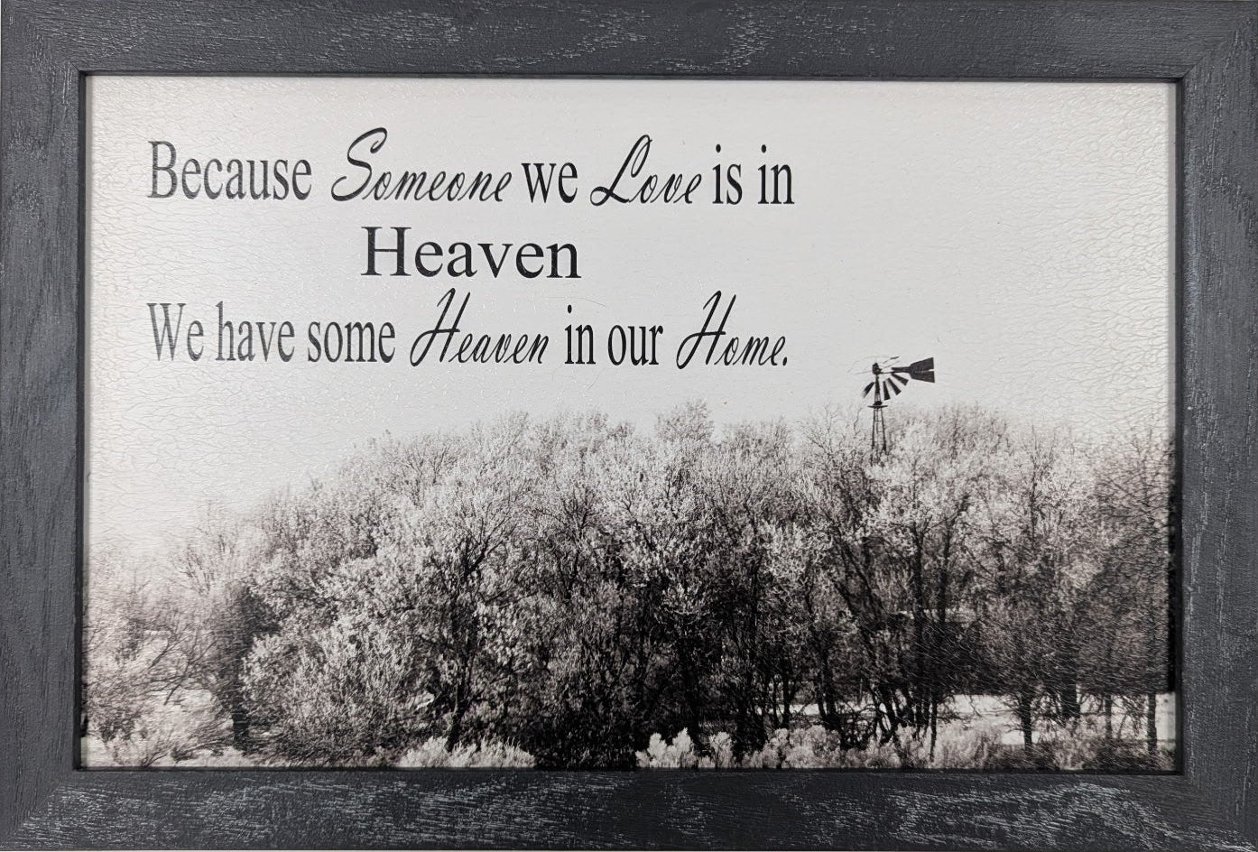 Framed picture with a black and white landscape and text on a white wall.