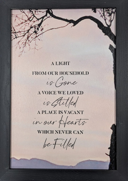 Framed print with a quote on a light pink background with tree branches.