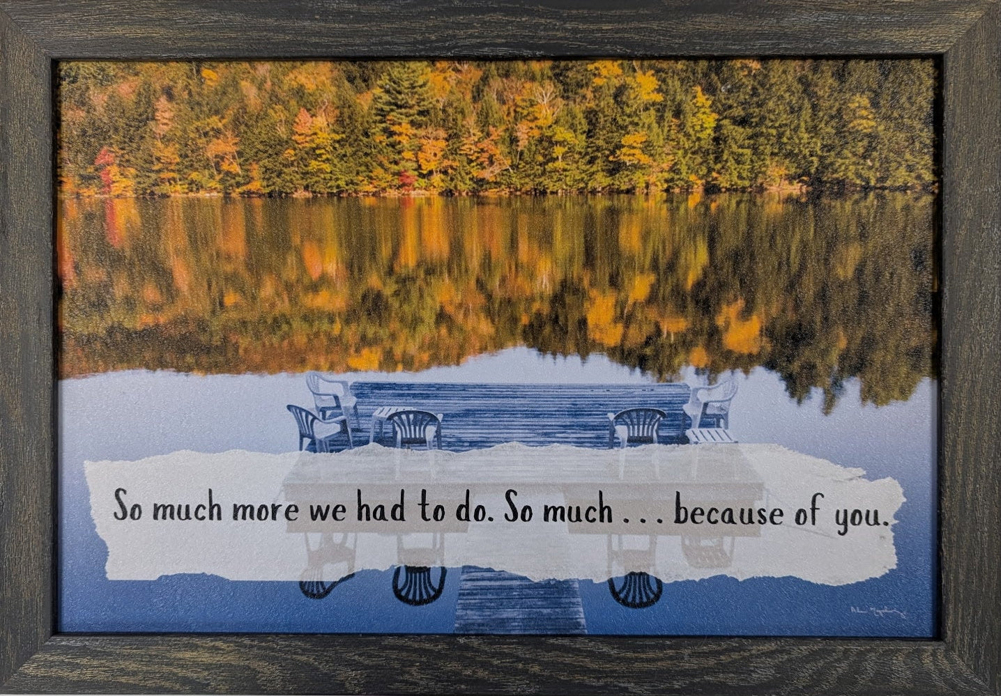 Framed artwork with a lake scene and text on a white wall