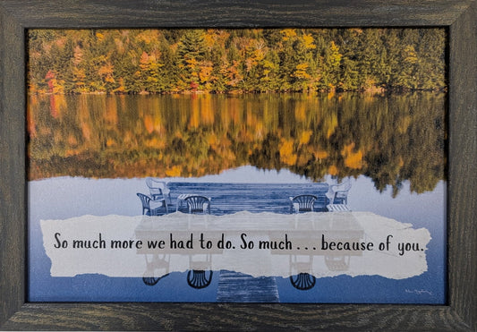 Framed artwork with a lake scene and text on a white wall