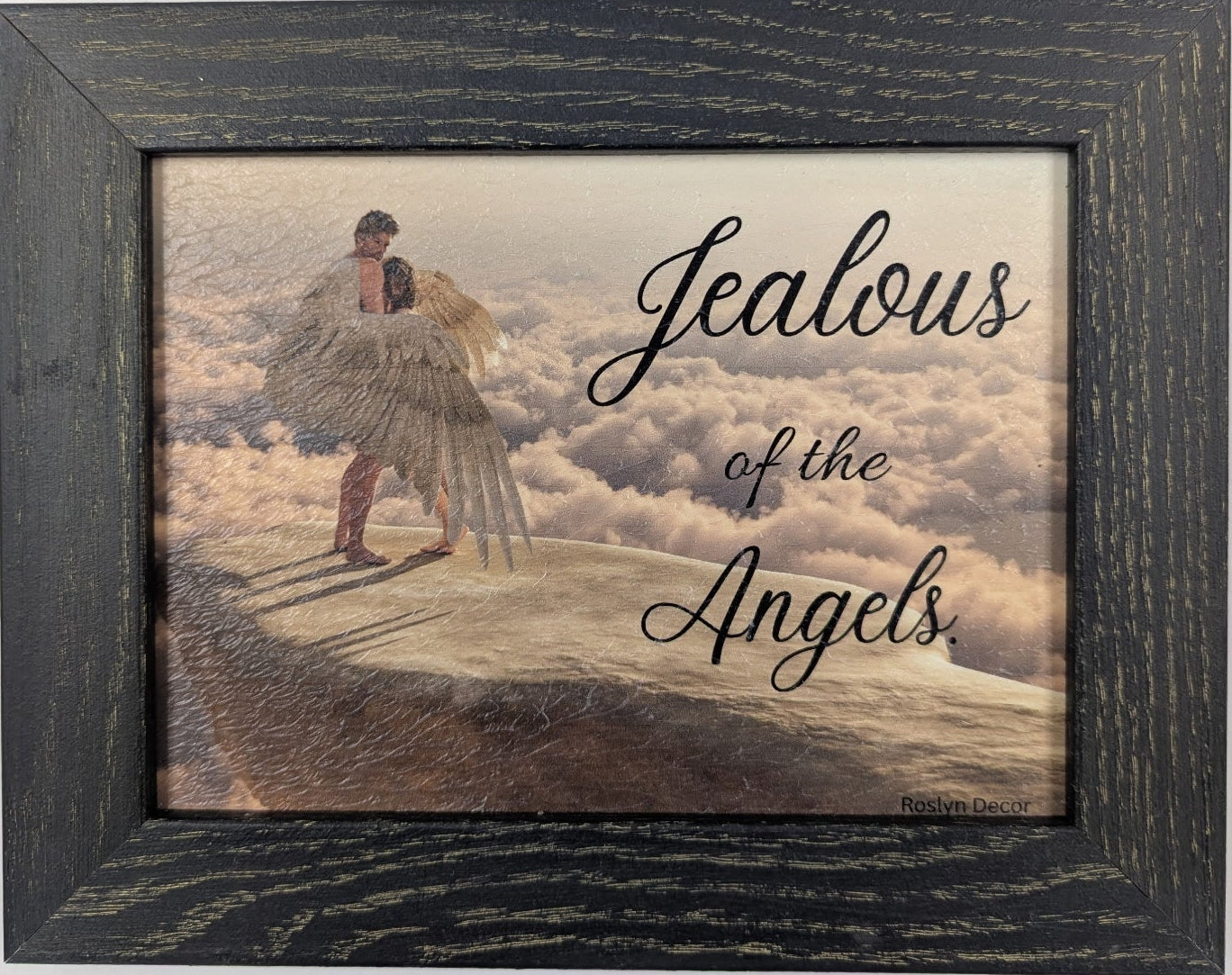 Framed artwork with a person on clouds and text 'Jealous of the Angels' on a white background