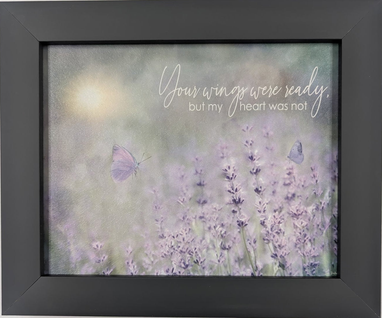 Framed artwork with lavender flowers and a butterfly on a light gray background