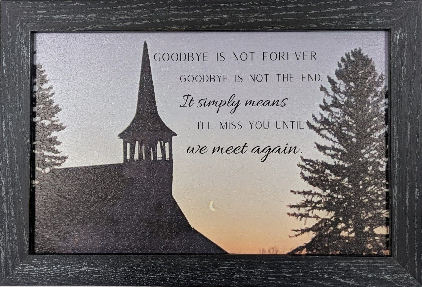 Framed artwork with silhouette of a church, trees, and sunset with inspirational quote.