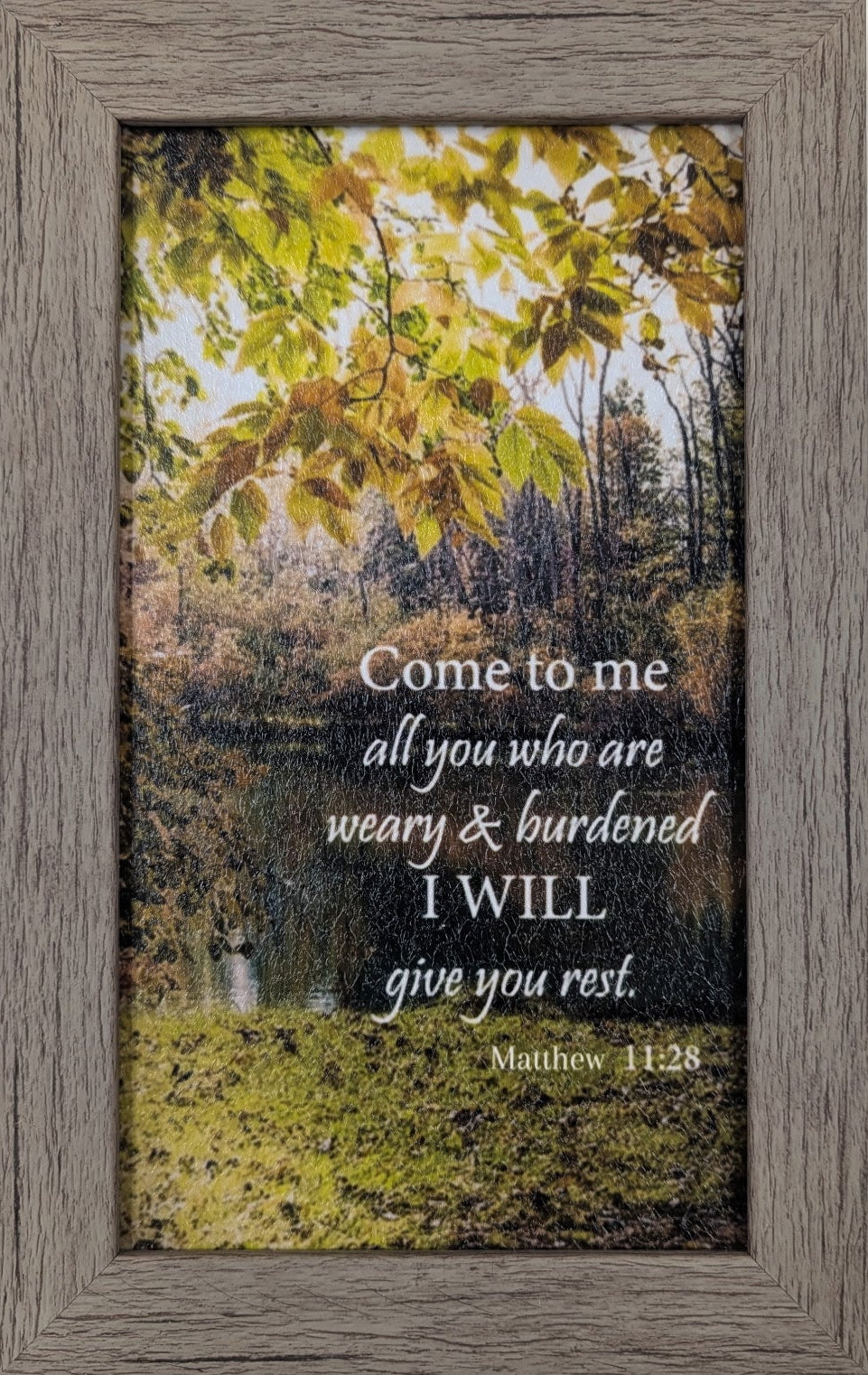 Framed print with nature scene and inspirational quote on a white wall