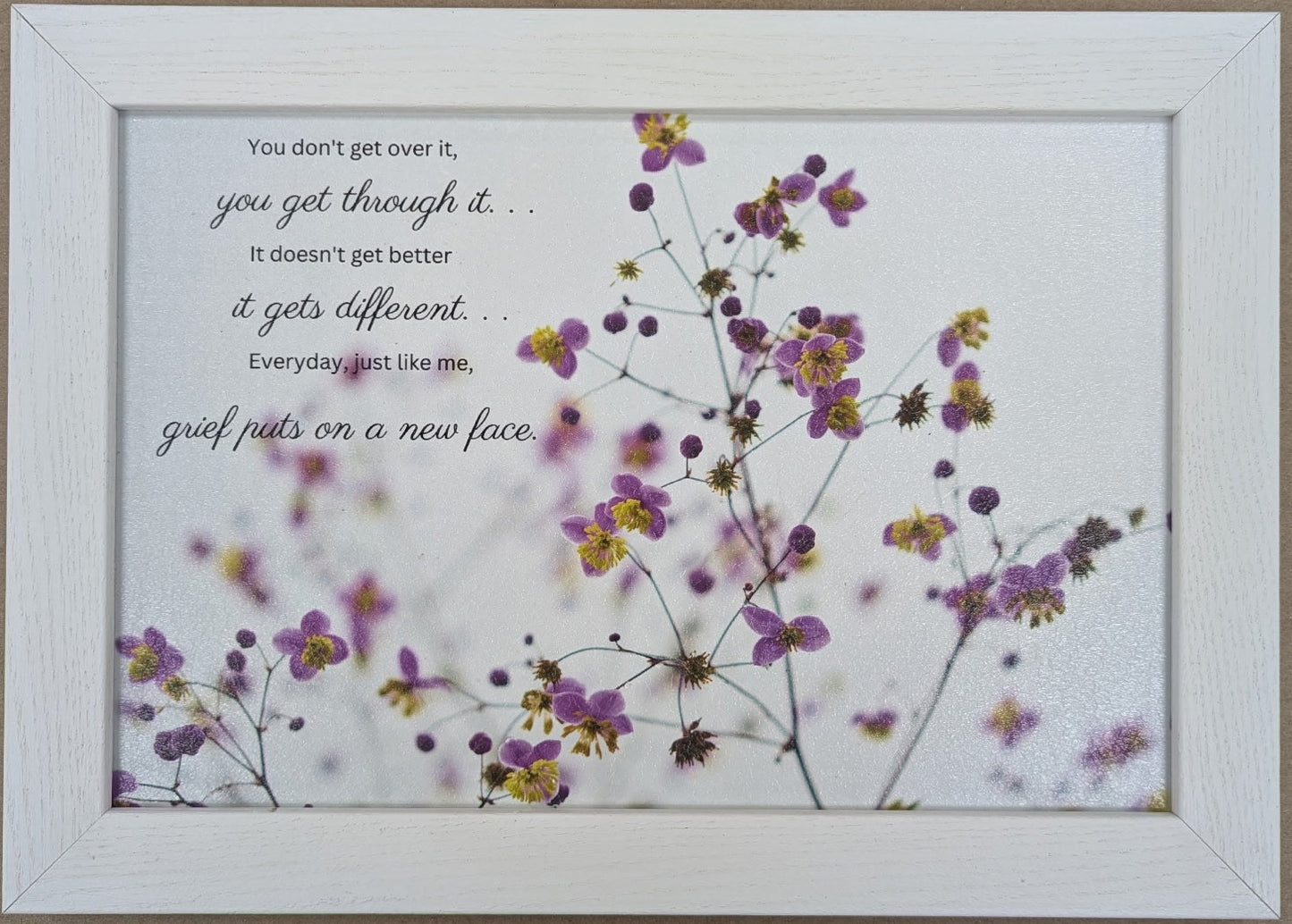 Framed artwork with flowers and motivational text on a white background