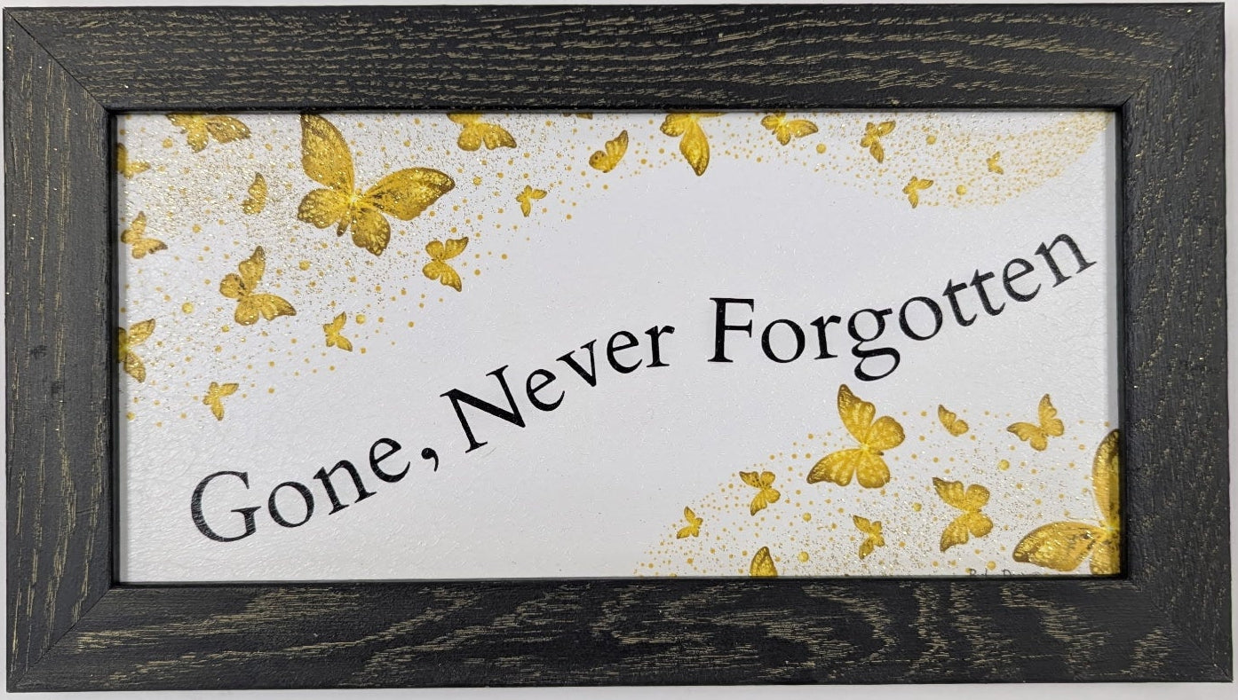 Framed artwork with 'Gone, Never Forgotten' text and gold butterflies on a white background.