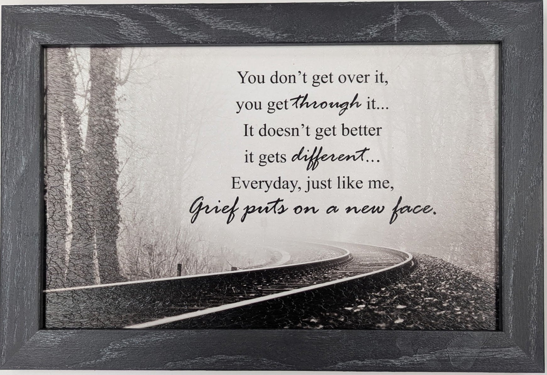 Framed print with a black and white landscape and inspirational quote on a light gray background