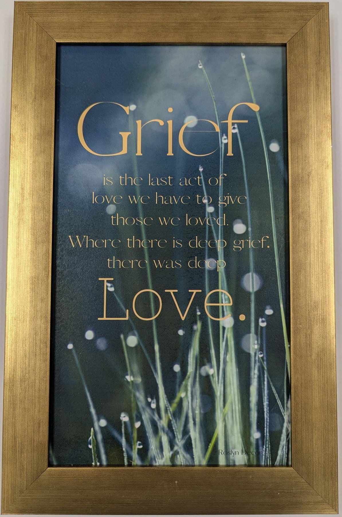 Framed quote about grief with a gold border on a light gray background