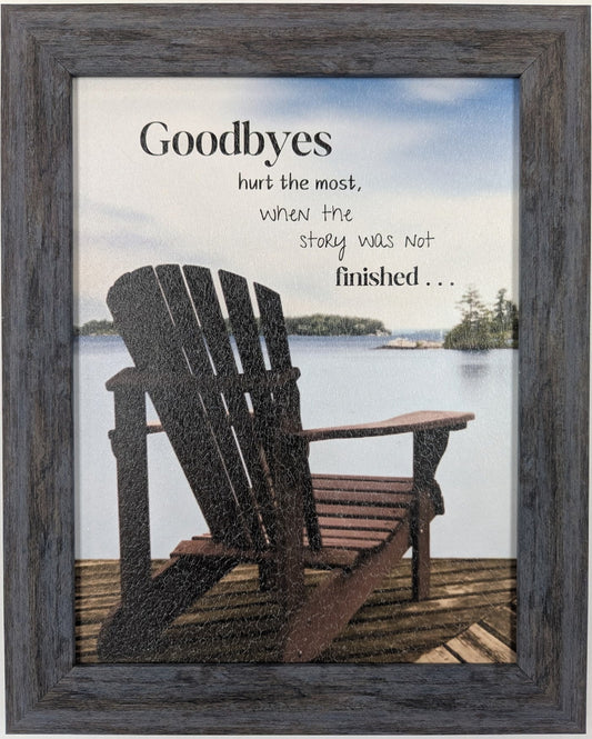 Framed artwork of two Adirondack chairs on a dock with a scenic background and text about goodbyes.