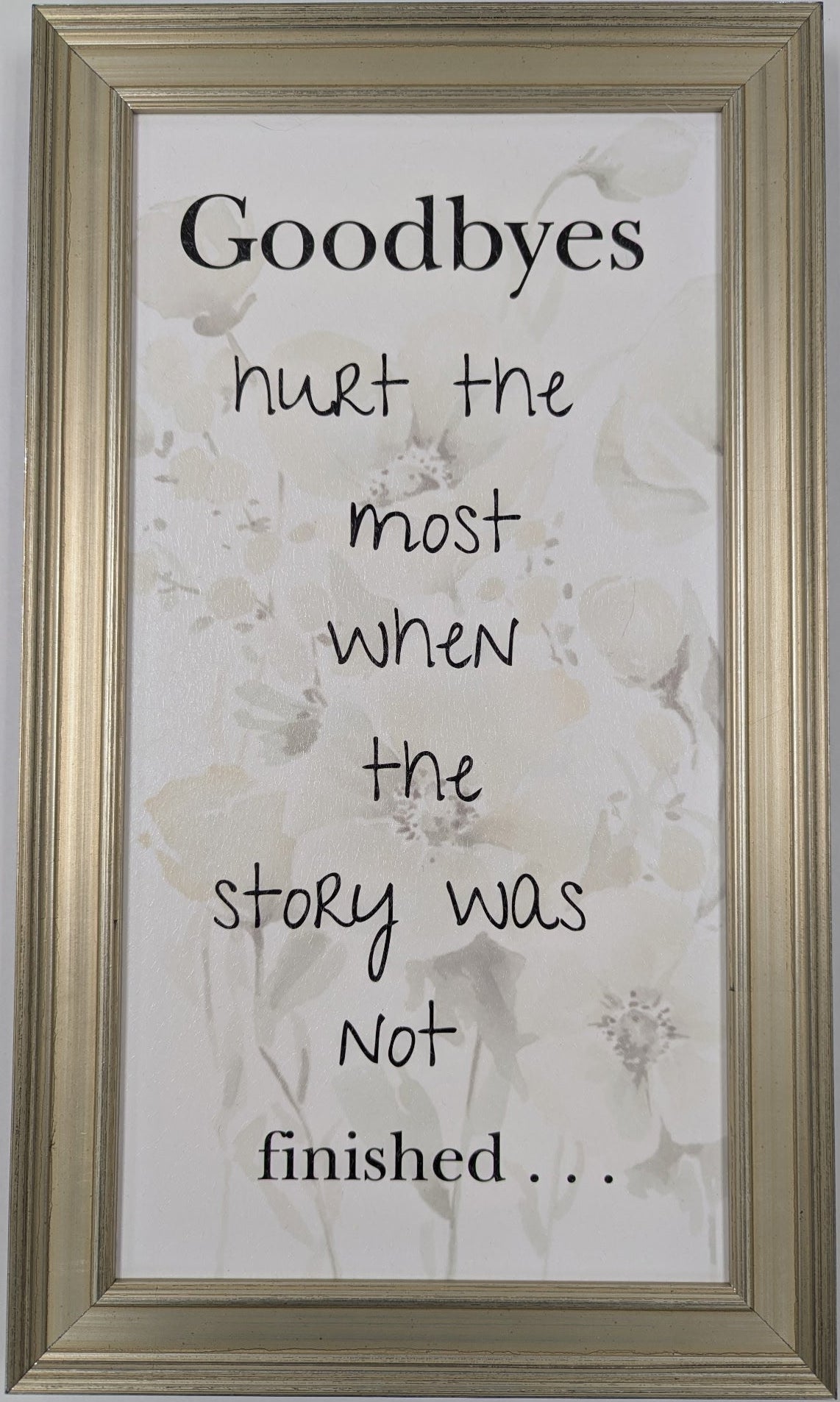 Framed quote on a floral background with a gold frame.