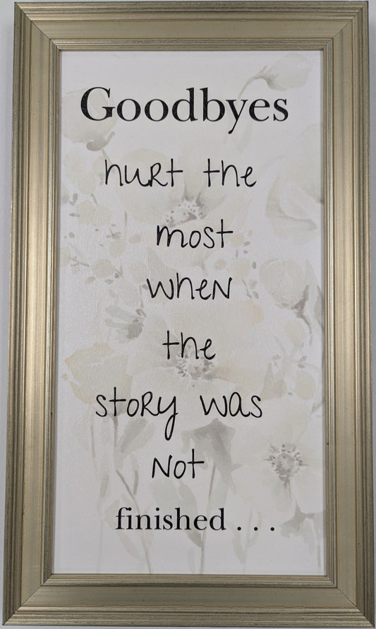 Framed quote on a floral background with a gold frame.